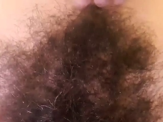 Fit babe plays with her natural hairy bush pussy
